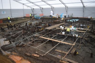 Must Farm under excavation. Archaeologists excavate while balancing on scaffolding just above the waterlogged wooden remains