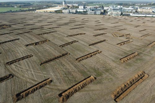 Aerial photo with over 50 trial trenches dug out from a large field in a regular pattern
