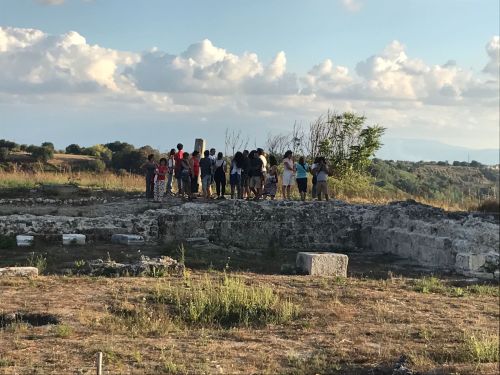 Children in the middle distance standing on stone ruins