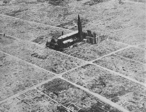 An aerial view of a church surrounded by flattened ruins