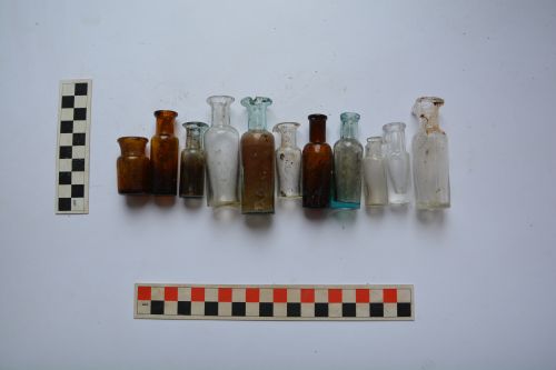 a selection of small pharmacy bottles next to measuring equipment