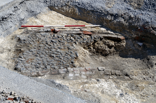 exposed cobblestones within an excavated trench