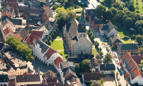 An aerial view of the church of St Stephanus in Beckum, Germany, before renovation. The green lawn is the church square; on the left is the market square. Copyright: Heimat- und Geschichtsverein Beckum.