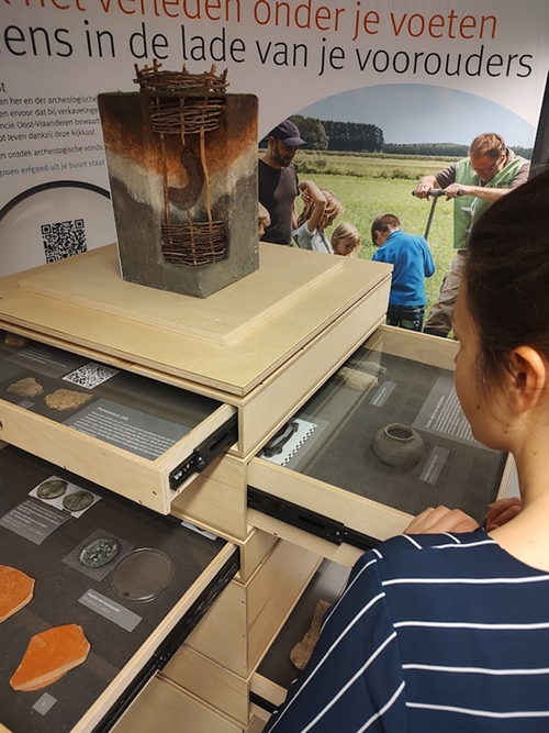 A mobile display case featuring archaeological finds and interpretive tools.