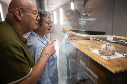 Visitors observing the storage facilities through the transparent viewing wall at the Ename repository.