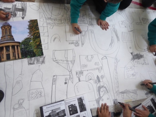 Photo from above of pupils from different schools drawing on a large sheet of paper on the topic of 'routes and journeys'