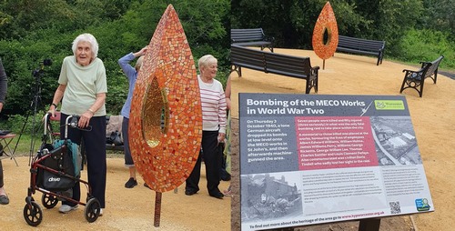 A couple of people standing next to a sculpture